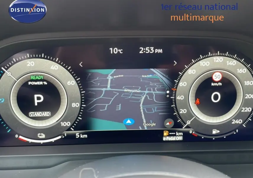 Tableau de bord numérique du Nissan Qashqai 1.5 E-POWER 2025 avec affichage GPS et compteurs ronds lumineux.