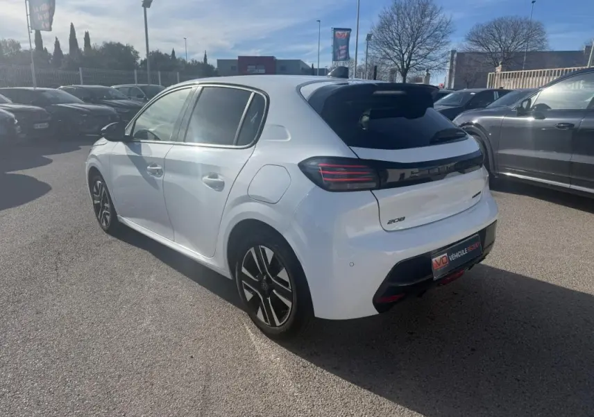 Peugeot 208 Hybrid blanc vue 3/4 arrière droit, avec feux arrière noirs et jantes alliage distinctives.