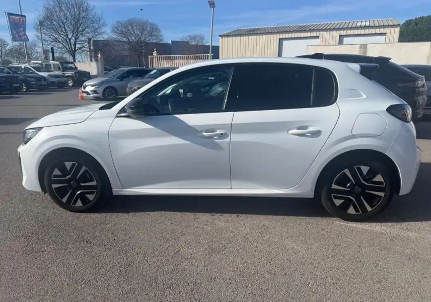 Vue latérale côté gauche d'une Peugeot 208 Hybrid 110 blanche avec jantes noires et détails modernes, modèle 2024.