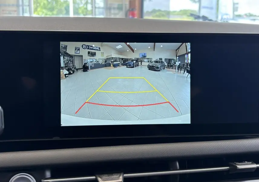 Vue écran caméra de recul intérieur du Hyundai Tucson 2026 Serenity White montrant l'espace derrière en showroom.