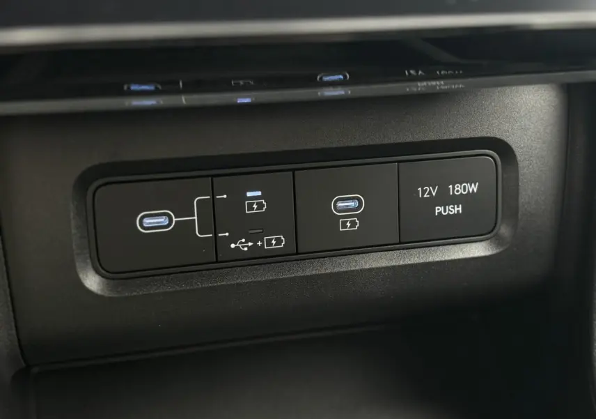 Gros plan sur les ports USB-C et prise 12V du tableau de bord du Hyundai Tucson 2026 en intérieur noir.
