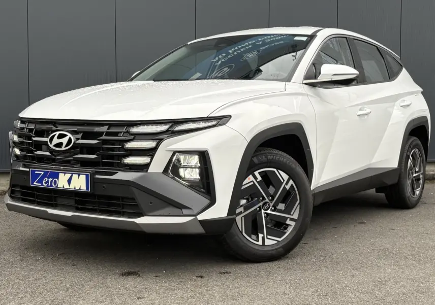 Hyundai Tucson 1.6 T-GDI Hybrid blanc Serenity vue 3/4 avant avec jantes alliage et calandre noire.