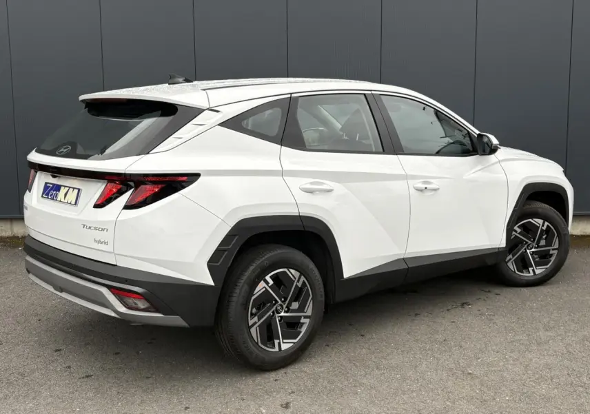 Vue 3/4 arrière droite d’un Hyundai Tucson Serenity White avec jantes alliage 17’’ et détails noirs contrastants.
