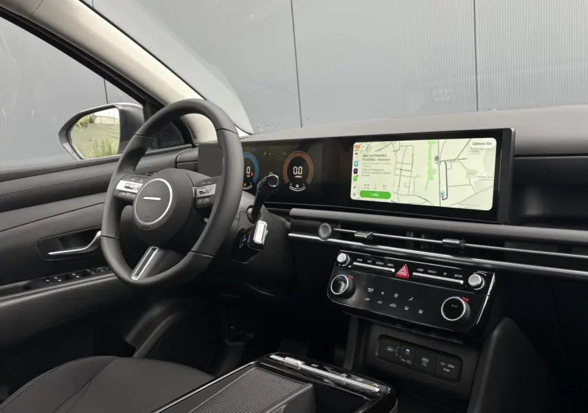 Vue intérieure côté conducteur du Hyundai Tucson blanc Serenity, avec tableau de bord numérique et écran tactile large.
