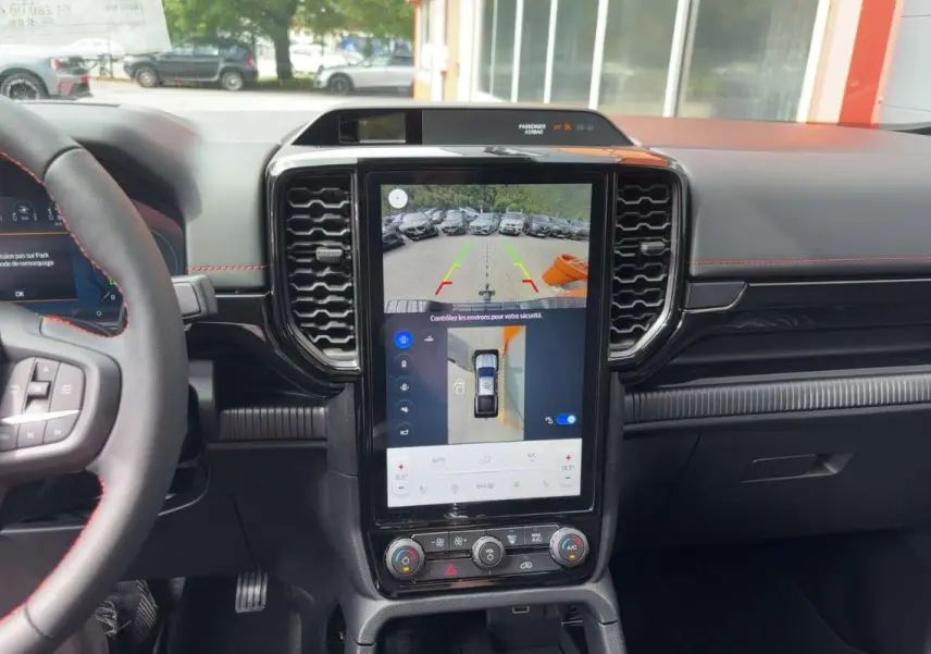Vue intérieure centrée sur la console centrale tactile verticale du Ford Ranger gris carbone 2026 avec volant multifonctions.