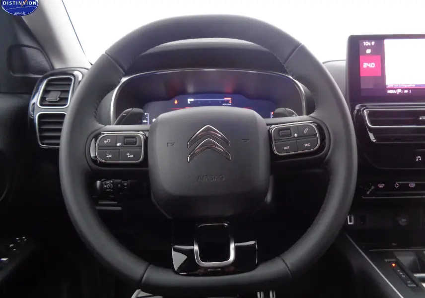 Vue rapprochée du volant noir du Citroën C5 Aircross 2022 avec commandes intégrées et tableau de bord numérique.