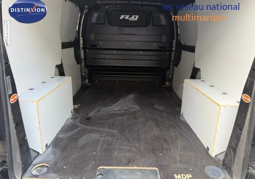 Vue intérieure arrière du fourgon Opel Vivaro gris, montrant l'espace de chargement avec planchers et protections latérales blanches.