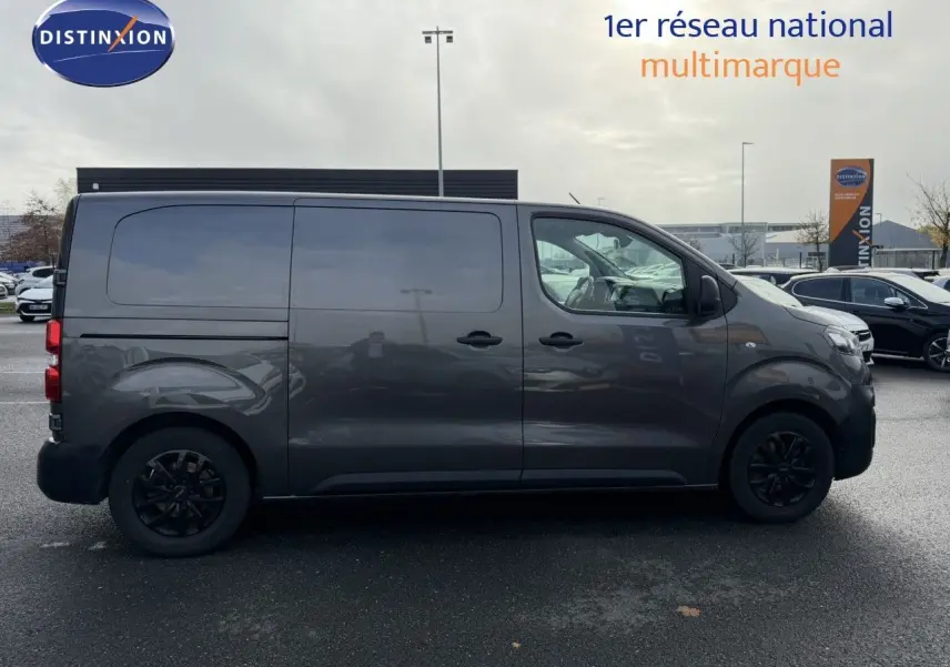 Profil droit d'un Opel Vivaro Fourgon gris Pierre de Lune métallisé avec jantes noires et vitres teintées.