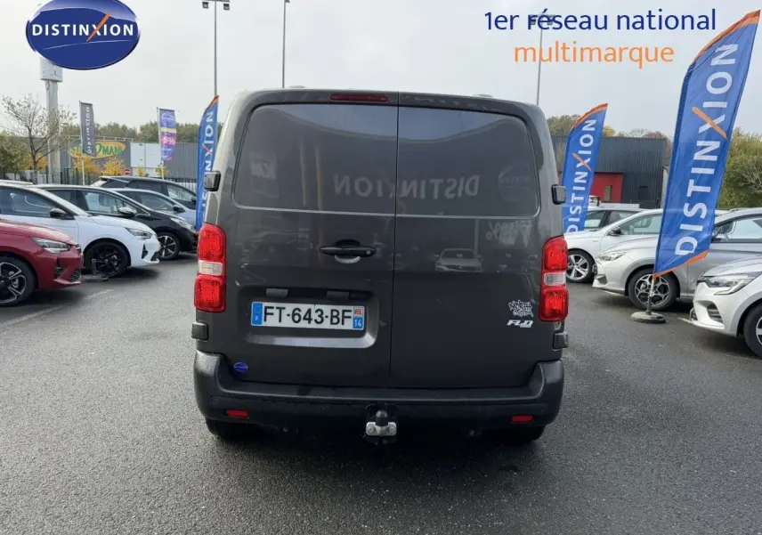 Vue arrière d'un Opel Vivaro Fourgon gris foncé avec attelage et plaque "OCCASION" visible sur un fond neutre.