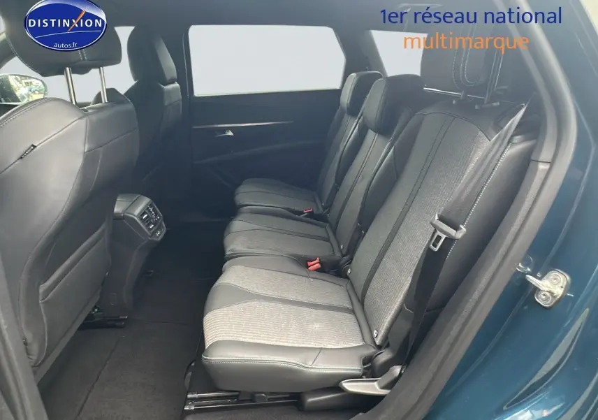 Vue latérale droite sur l'intérieur arrière bleu du Peugeot 5008 2024 avec sièges en tissu et cuir noir.