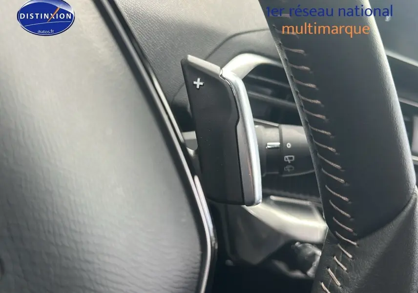 Gros plan sur la palette de changement de vitesse à droite du volant cuir noir du Peugeot 5008 bleu 2024.