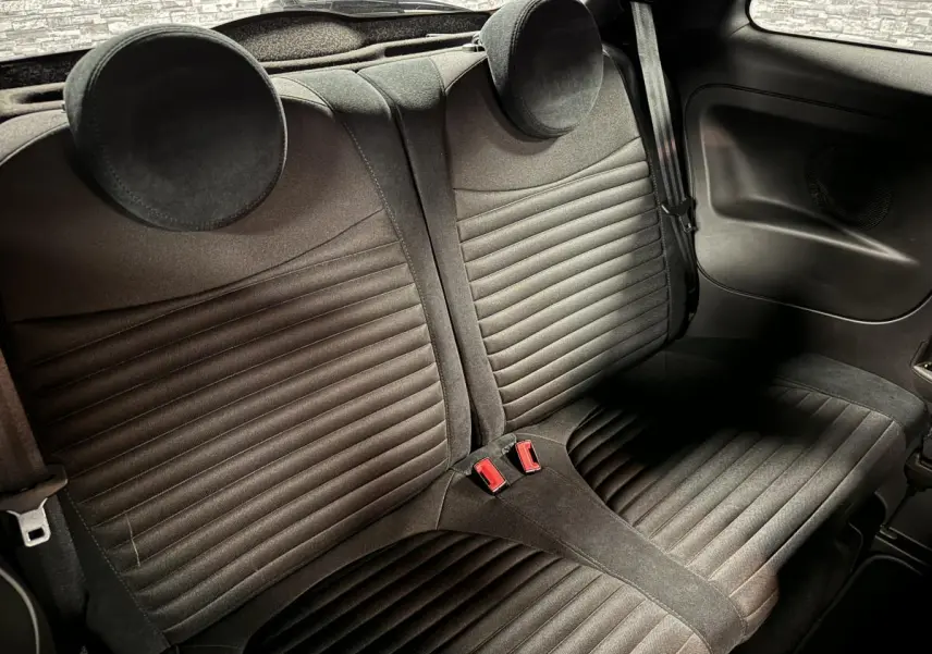 Vue intérieure de la banquette arrière en tissu noir de l'Abarth 595 Competizione 2022 avec appuie-têtes ronds.