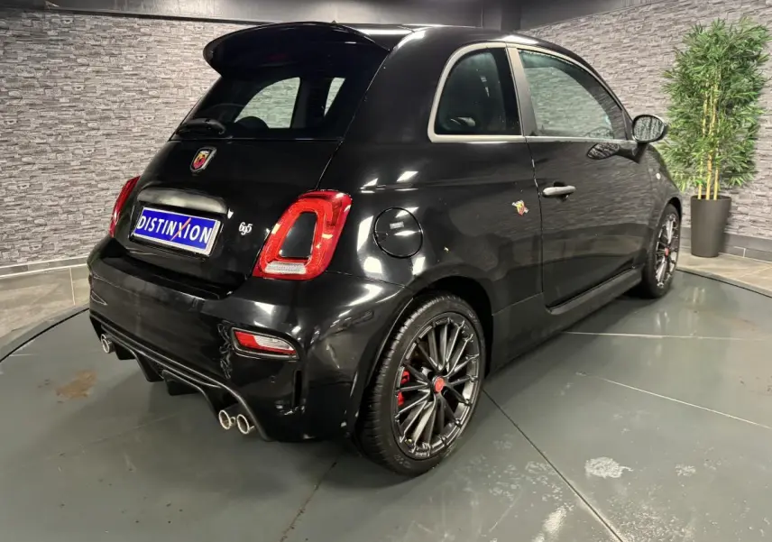 Vue 3/4 arrière droite de l'Abarth 595 Competizione noire avec jantes alliage et échappement quadruple chromé.