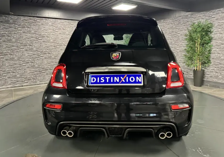 Vue arrière d'une ABARTH 595 noire avec quadruple sortie d'échappement chromée et feux arrière LED rouges.
