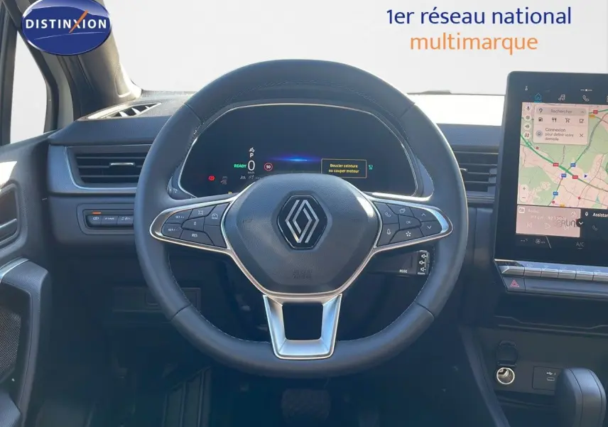 Vue centrée sur le volant du Renault Captur E-Tech hybride 2025, avec tableau de bord numérique et écran tactile visible.