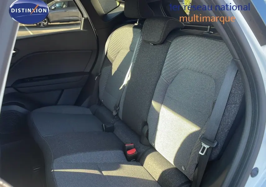 Vue intérieure des sièges arrière en tissu gris du Renault Captur E-Tech hybride blanc nacré avec toit noir, porte ouverte côté droit.