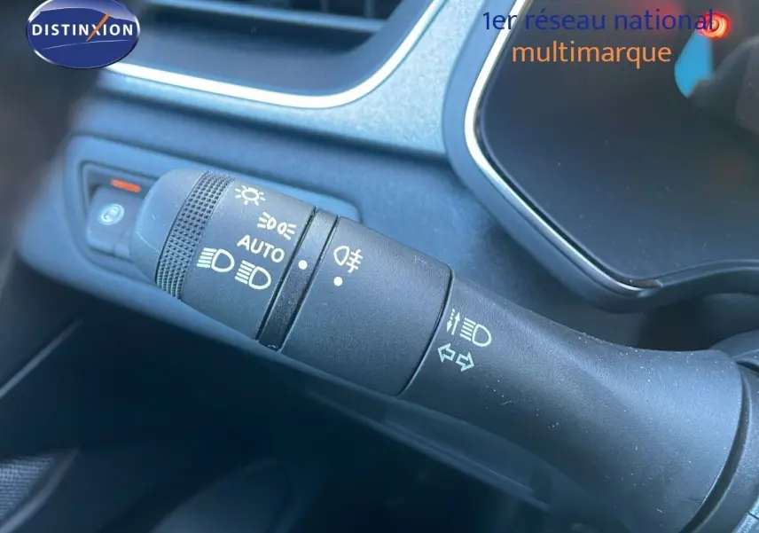 Gros plan sur la commande des phares et clignotants dans l'habitacle du Renault Captur blanc nacré 2025.