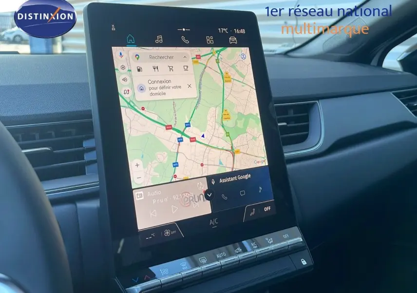 Vue rapprochée de l'écran tactile central du tableau de bord du Renault Captur blanc nacré 2025 avec navigation affichée.