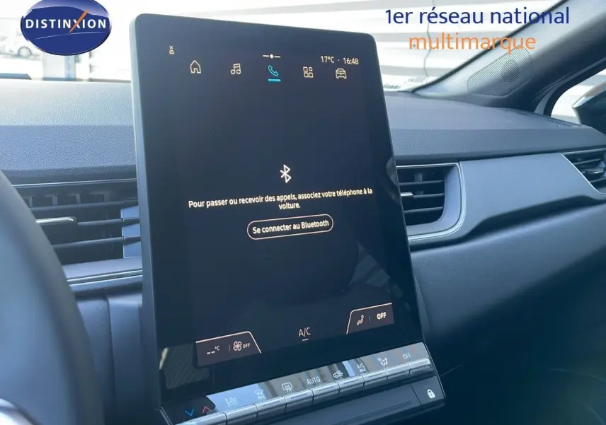 Intérieur du Renault Captur E-Tech 2025, vue sur l'écran tactile central et la planche de bord noire moderne.