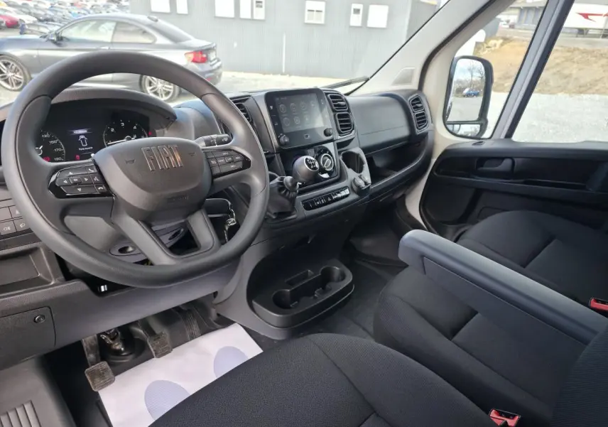 Vue intérieure côté conducteur du Fiat Ducato Fourgon 2025 avec tableau de bord noir et écran tactile 7 pouces.