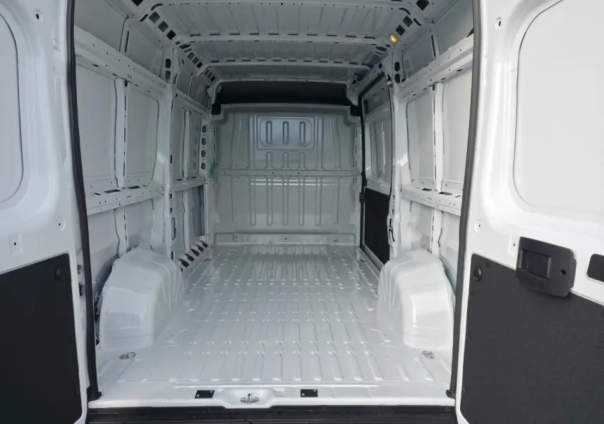 Intérieur blanc du fourgon FIAT Ducato Tôlé 3.3 L H2 2.2, vue de l’arrière avec portes ouvertes et espace de chargement vide.