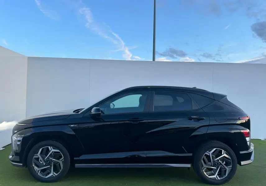 Vue de profil côté gauche du Hyundai Kona II noir Abyss Metal avec jantes alliage 18 pouces et détails N Line.