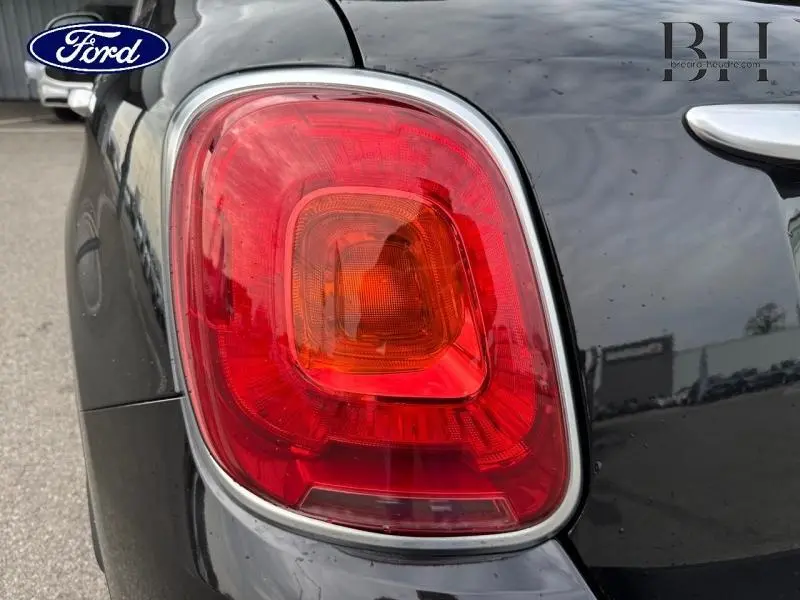 Gros plan sur le feu arrière gauche d'une FIAT 500X noir Cinéma pastel extra-série, avec contour chromé visible.