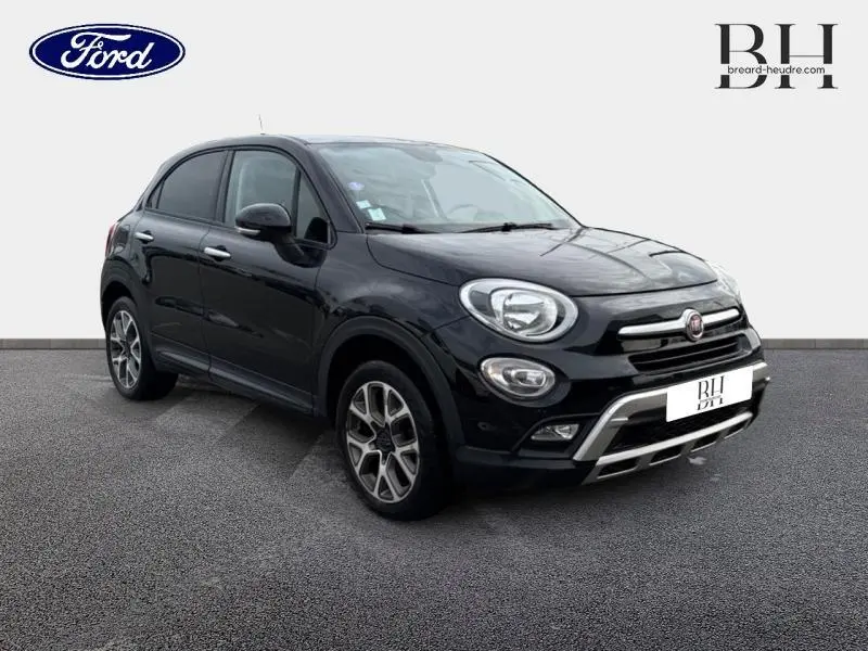 Fiat 500X noir Cinéma pastel en vue 3/4 avant droit, avec jantes alu et barres de toit visibles.