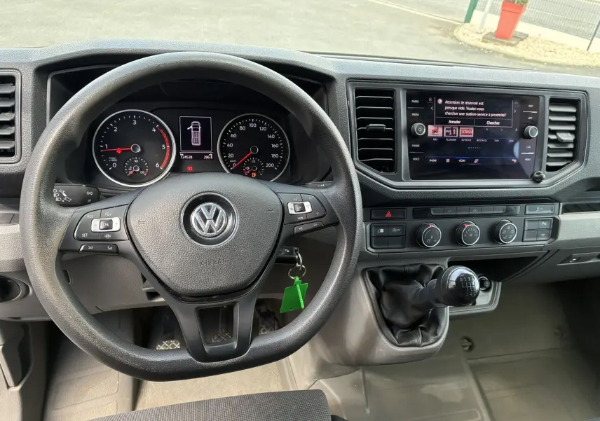 Vue intérieure du tableau de bord et volant noir du Volkswagen Crafter Fourgon avec levier de vitesses manuel et écran tactile.