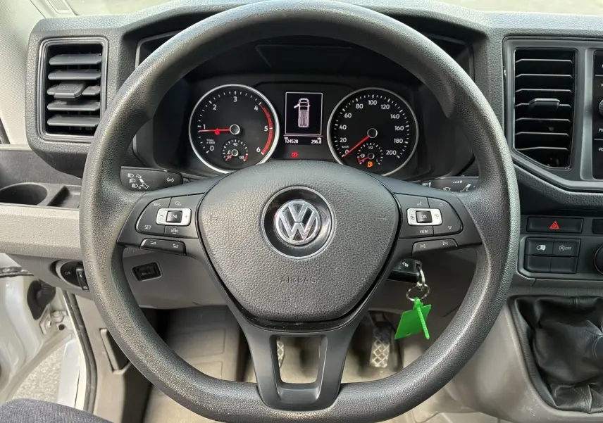 Vue frontale du volant noir de Volkswagen Crafter 2.0 TDI 2020 avec tableau de bord et commandes multifonctions visibles.