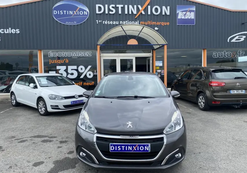 Vue avant d'une Peugeot 208 gris métallisé 2018, avec feux allumés et calandre chromée visible.
