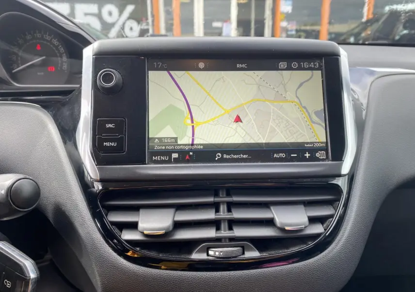 Vue rapprochée de l’écran tactile central et des aérateurs noirs du tableau de bord de la Peugeot 208 gris 2018.