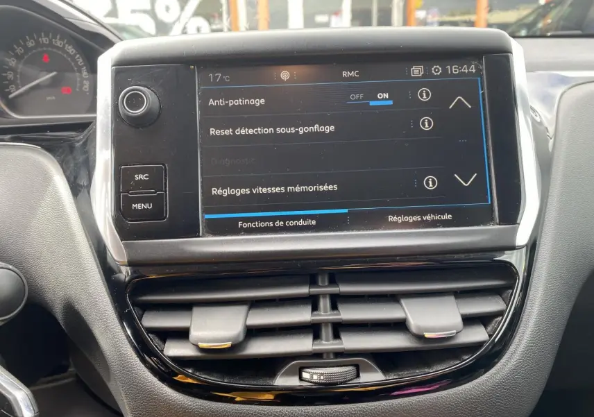 Vue rapprochée de la console centrale de la Peugeot 208 grise, avec écran tactile affichant les réglages de conduite.