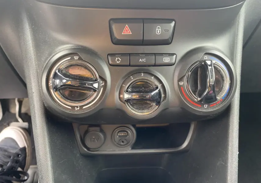 Gros plan sur le bouton de réglage de la température du système de climatisation dans une Peugeot 208 gris 2018.