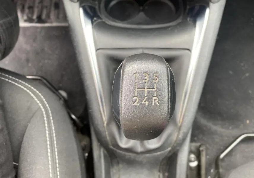 Vue rapprochée du levier de vitesses manuel noir dans l’habitacle d’une Peugeot 208 gris 2018.