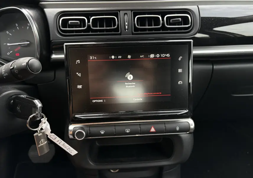 Vue rapprochée du tableau de bord de la Citroën C3 beige 2019, mettant en valeur l'écran tactile central et les commandes.