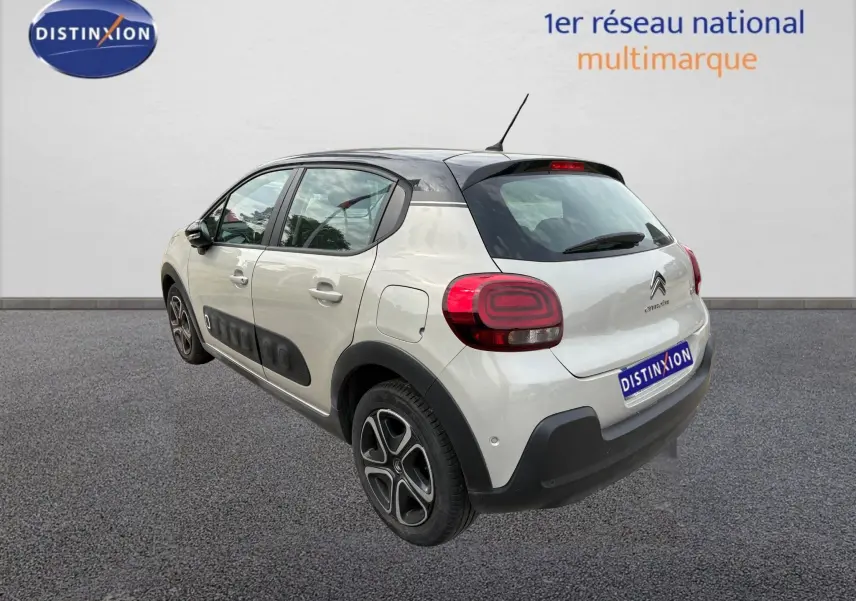 Vue 3/4 arrière droite d'une Citroën C3 beige 2019 avec toit noir et protections latérales noires.
