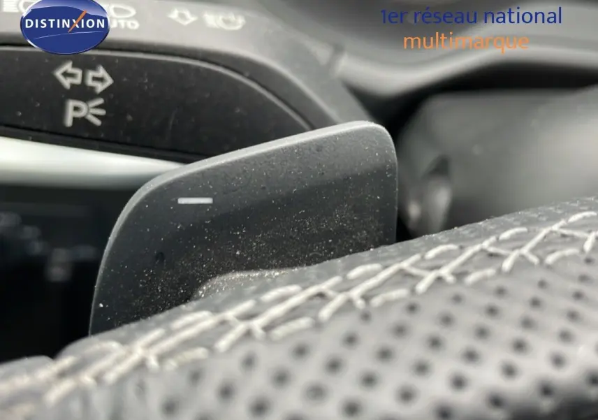 Gros plan sur la palette de changement de vitesse noire et le volant cuir perforé de l’Audi Q2 35 2.0 TDI S-Line.