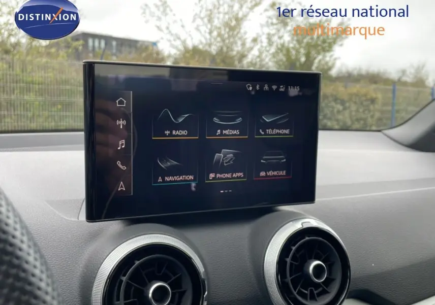 Écran tactile central et aérateurs ronds dans l’habitacle noir d’un Audi Q2 35 2.0 TDI S-Line 2025.