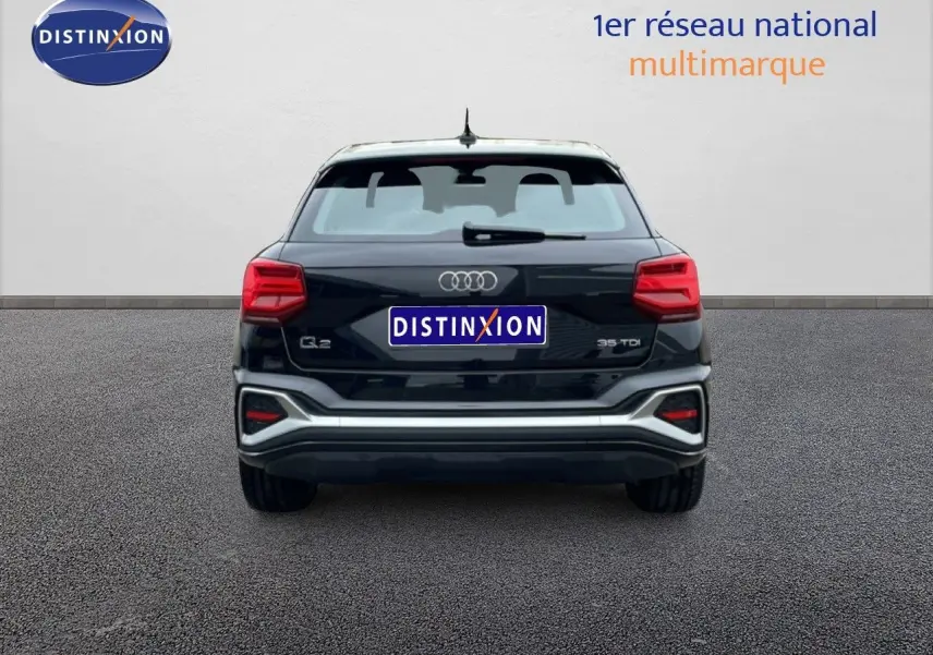 Vue arrière d'un Audi Q2 noir mito metal 35 TDI 2025 avec feux LED et détails chromés sur le pare-chocs.