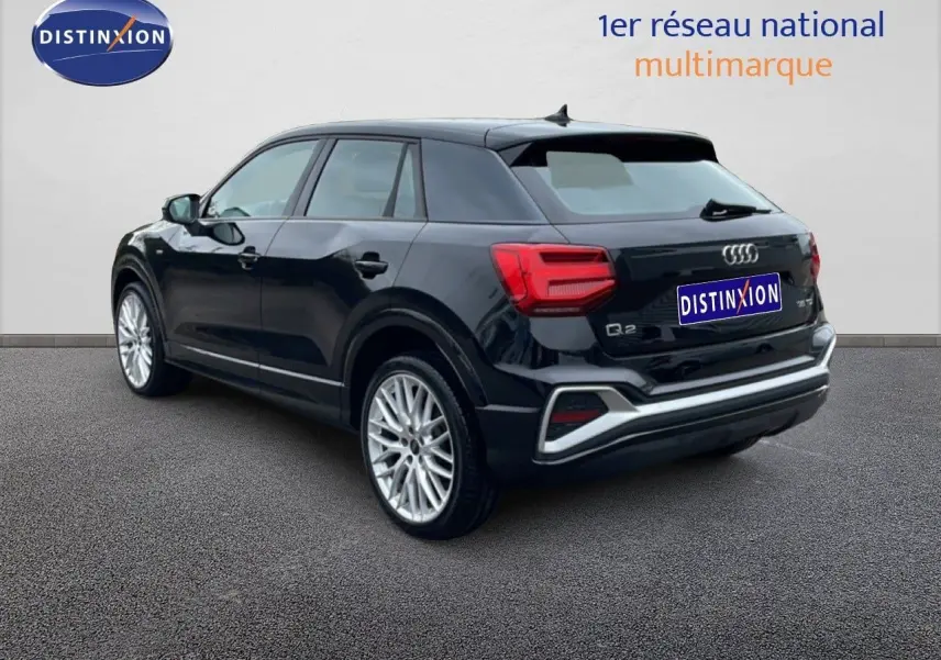 Audi Q2 noir mito metal en 3/4 arrière droit, mettant en valeur ses jantes alliage et ses feux arrière LED distinctifs.