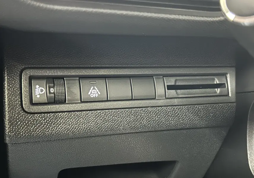 Détail intérieur du tableau de bord côté gauche du Peugeot 5008 bleu, montrant les commandes d'éclairage et d'assistance.