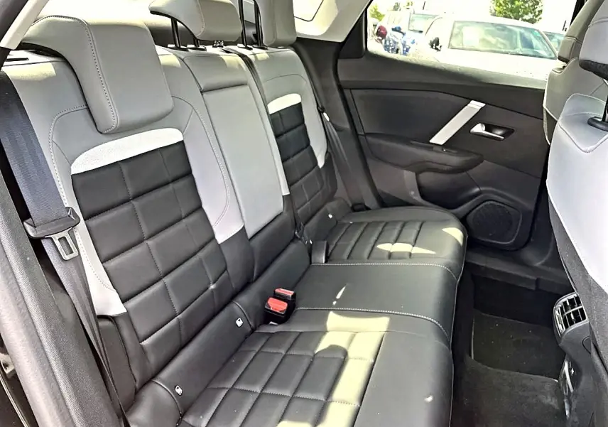 Vue intérieure montrant la banquette arrière bicolore noire et grise du Citroën C4 X 2025, côté droit.