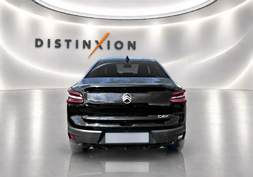 Vue arrière d'une Citroën C4 X noire 2025 avec feux LED et double sortie d'échappement chromée dans un showroom.