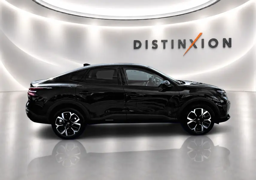 Profil côté gauche de la Citroën C4 X noire 2025 avec jantes alu distinctives dans un studio lumineux.