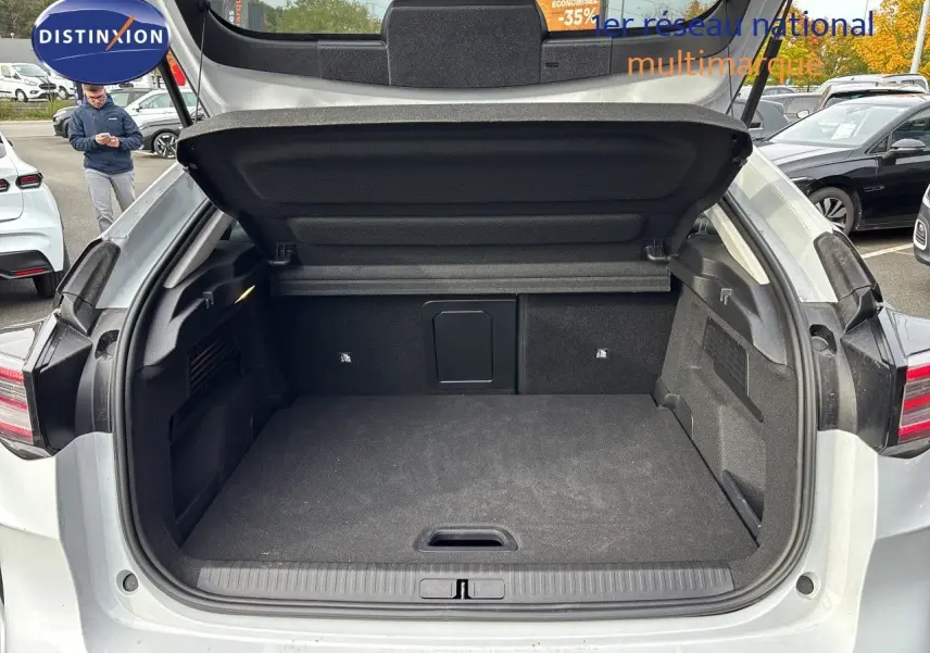 Coffre ouvert vu de l'arrière d'une Citroën C4 Hybrid blanche, montrant un espace de chargement propre et spacieux.