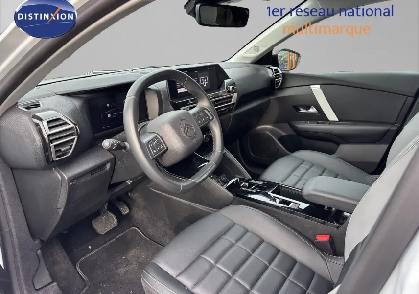 Vue intérieure côté conducteur de la Citroën C4 Hybrid 2025 avec sièges cuir gris et tableau de bord moderne noir.