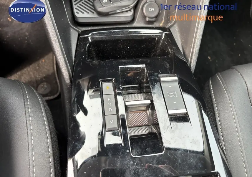 Gros plan sur la console centrale noire brillante de la Citroën C4 Hybrid 145ch, avec sélecteur de boîte auto et bouton Drive Mode.