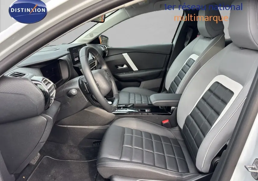 Vue intérieure côté conducteur de la Citroën C4 Hybrid 145ch 2025 avec sièges cuir bicolores gris et noir.