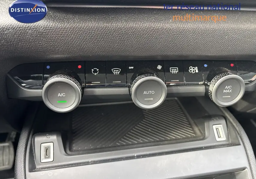 Gros plan sur la console centrale de la Citroën C4 Hybrid 2025, montrant les commandes de climatisation et deux ports USB.